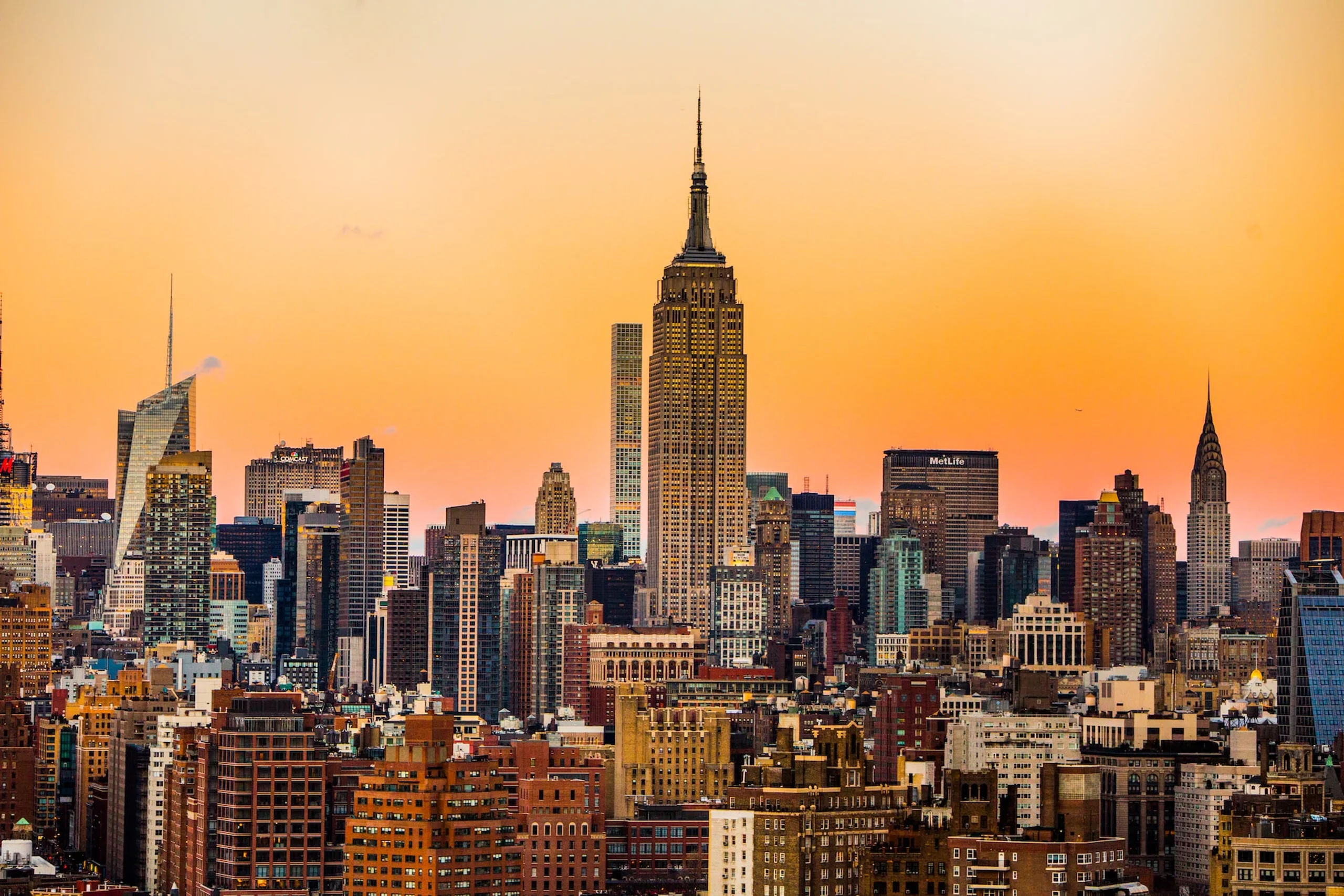 City skyline of skyscrapers with orange hue of sunset in the sky