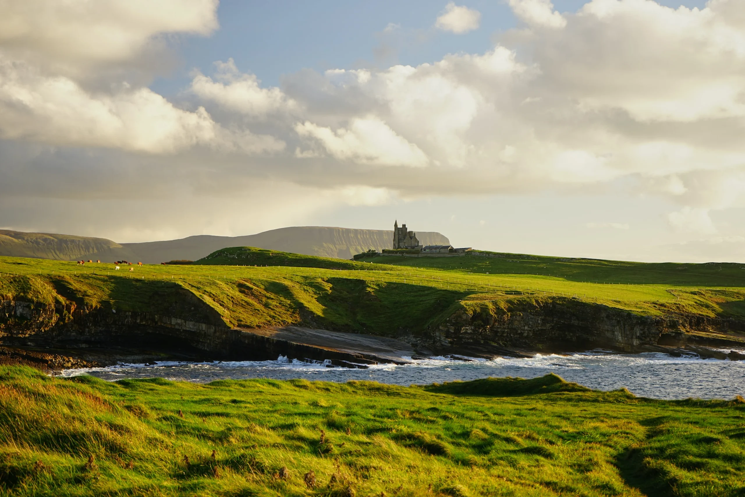 Green hills beside the ocean and a castle on the hill
